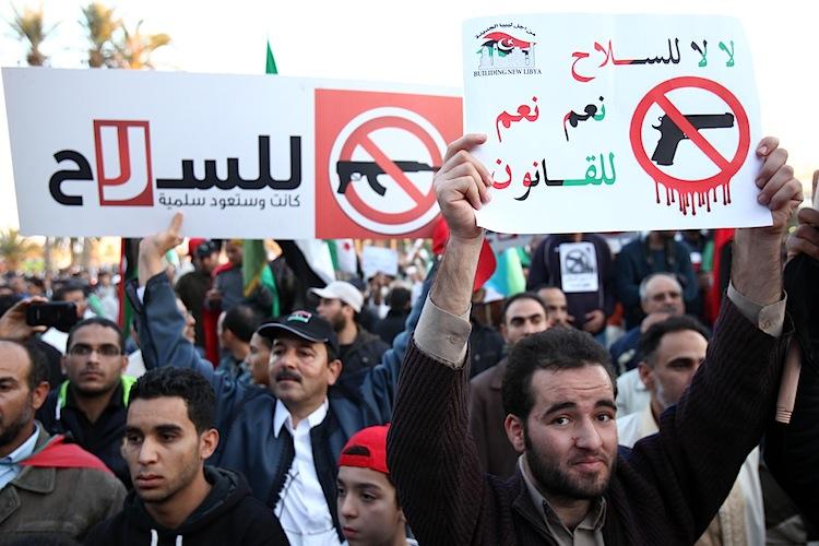 <a><img class="size-large wp-image-1794366" src="https://www.theepochtimes.com/assets/uploads/2015/09/Libya_disarmament_135375401.jpg" alt="Libyan demonstrators hold a banner" width="590" height="393"/></a>