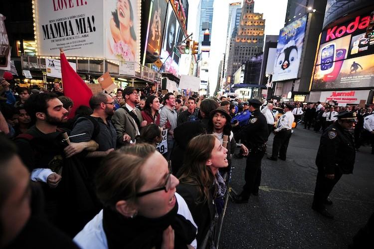 <a><img src="https://www.theepochtimes.com/assets/uploads/2015/09/Occupy852ARMS.jpg" alt="Occupy Wall Street participants link arms to try to push trough police barricade on Times Square in New York on Oct. 15. (Emmanuel Dunand/Getty Images)" title="Occupy Wall Street participants link arms to try to push trough police barricade on Times Square in New York on Oct. 15. (Emmanuel Dunand/Getty Images)" width="575" class="size-medium wp-image-1796305"/></a>