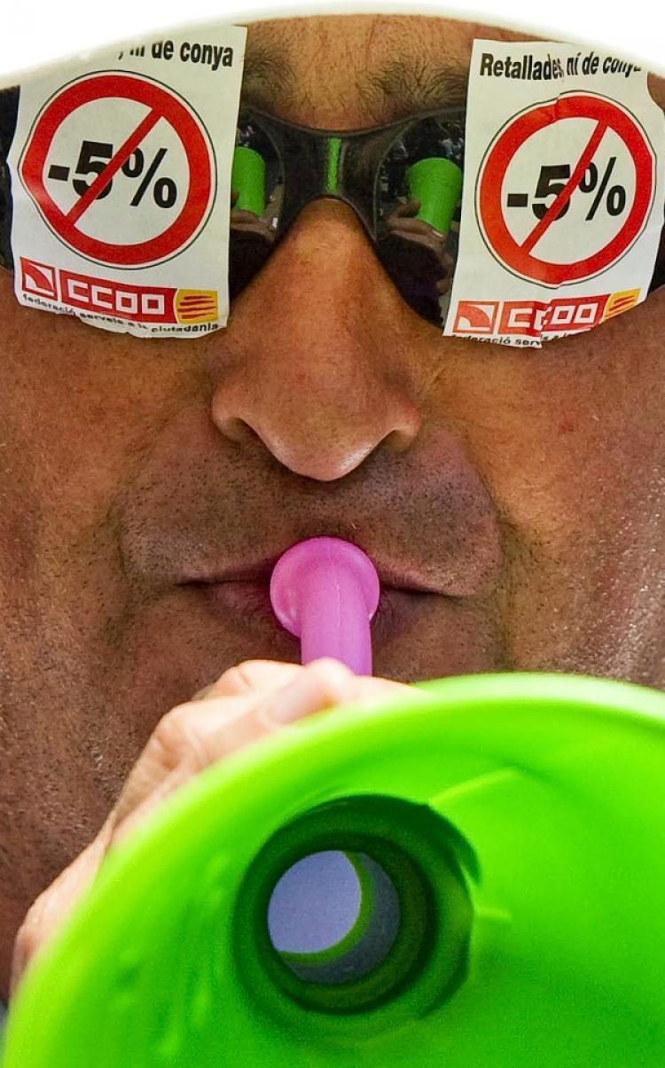 <a><img src="https://www.theepochtimes.com/assets/uploads/2015/09/SPAIN-101877412.jpg" alt="A man protests the government's proposed five percent cut in public sector wages during a worker strike in Barcelona on June 8. (Josep Lago/AFP/Getty Images)" title="A man protests the government's proposed five percent cut in public sector wages during a worker strike in Barcelona on June 8. (Josep Lago/AFP/Getty Images)" width="320" class="size-medium wp-image-1818525"/></a>