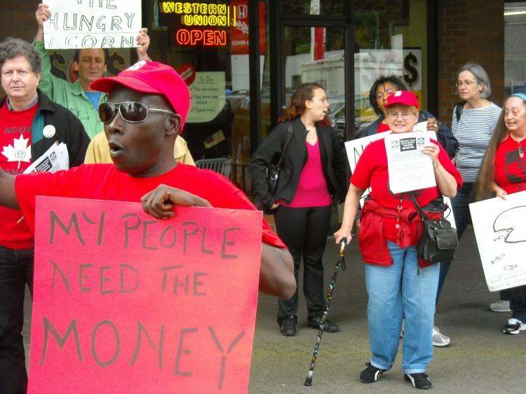 <a><img src="https://www.theepochtimes.com/assets/uploads/2015/09/img.jpg" alt="Pascal Apuwa (forefront) demonstrates with fellow ACORN members outside a Money Mart in Burnaby, B.C., against the unreasonably high fees placed on remittance payments by money transfer organizations. (Acorn Canada)" title="Pascal Apuwa (forefront) demonstrates with fellow ACORN members outside a Money Mart in Burnaby, B.C., against the unreasonably high fees placed on remittance payments by money transfer organizations. (Acorn Canada)" width="320" class="size-medium wp-image-1799760"/></a>