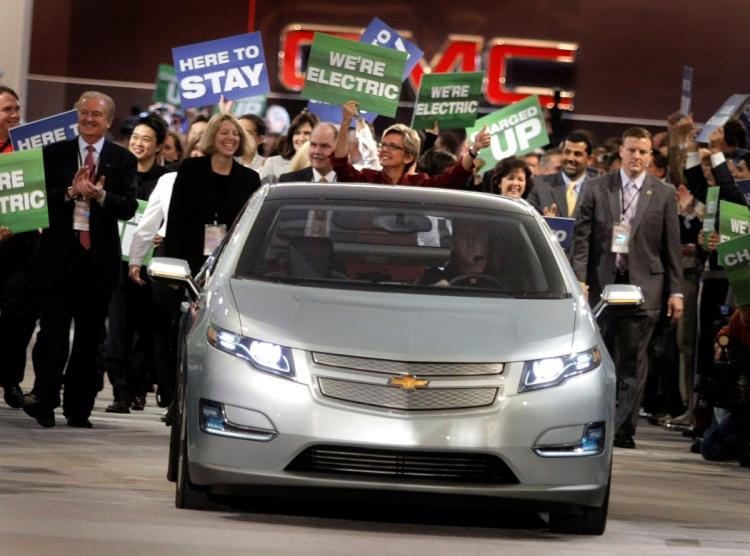 <a><img src="https://www.theepochtimes.com/assets/uploads/2015/09/volt_lowres.jpg" alt="LEANER AND GREENER: Michigan Gov. Jennifer Granholm (red dress) marches with auto workers and dignitaries behind a Chevy Volt electric vehicle during the introduction of General Motors' vehicles during the press preview for the Detroit International Auto (Bill Pugliano/Getty Images)" title="LEANER AND GREENER: Michigan Gov. Jennifer Granholm (red dress) marches with auto workers and dignitaries behind a Chevy Volt electric vehicle during the introduction of General Motors' vehicles during the press preview for the Detroit International Auto (Bill Pugliano/Getty Images)" width="320" class="size-medium wp-image-1831408"/></a>