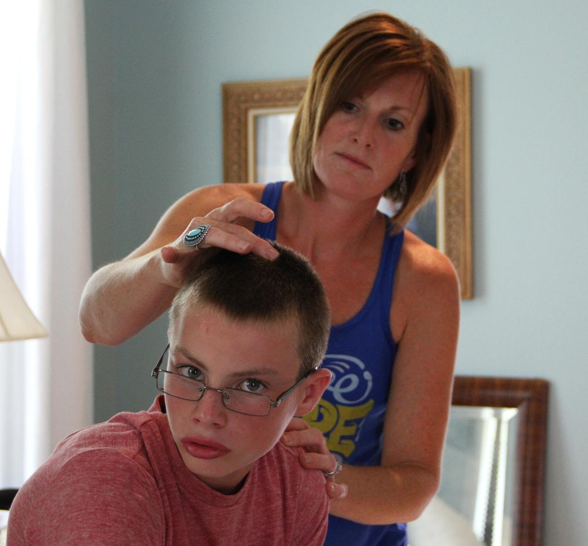 Shannon Coconis puts essential oil on her son Sam (12) who has autism, to help him sleep better. (Courtesy of OSU's Wexner Medical Center)