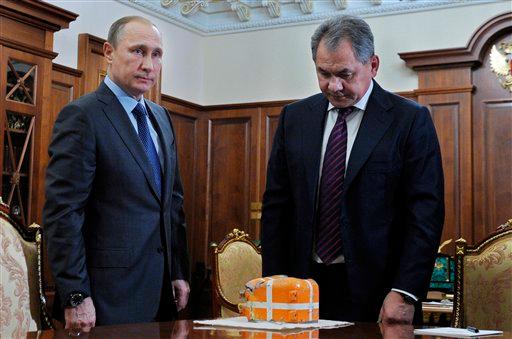 Russian Defense Minister Sergei Shoigu, right, shows President Vladimir Putin a flight recorder of a Russian warplane shot down by a Turkish jet on Nov. 24, in the Novo-Ogaryovo residence outside Moscow, Russia, Tuesday, Dec. 8, 2015. (Mikhail Klimentyev/Sputnik, Kremlin Pool Photo via AP)