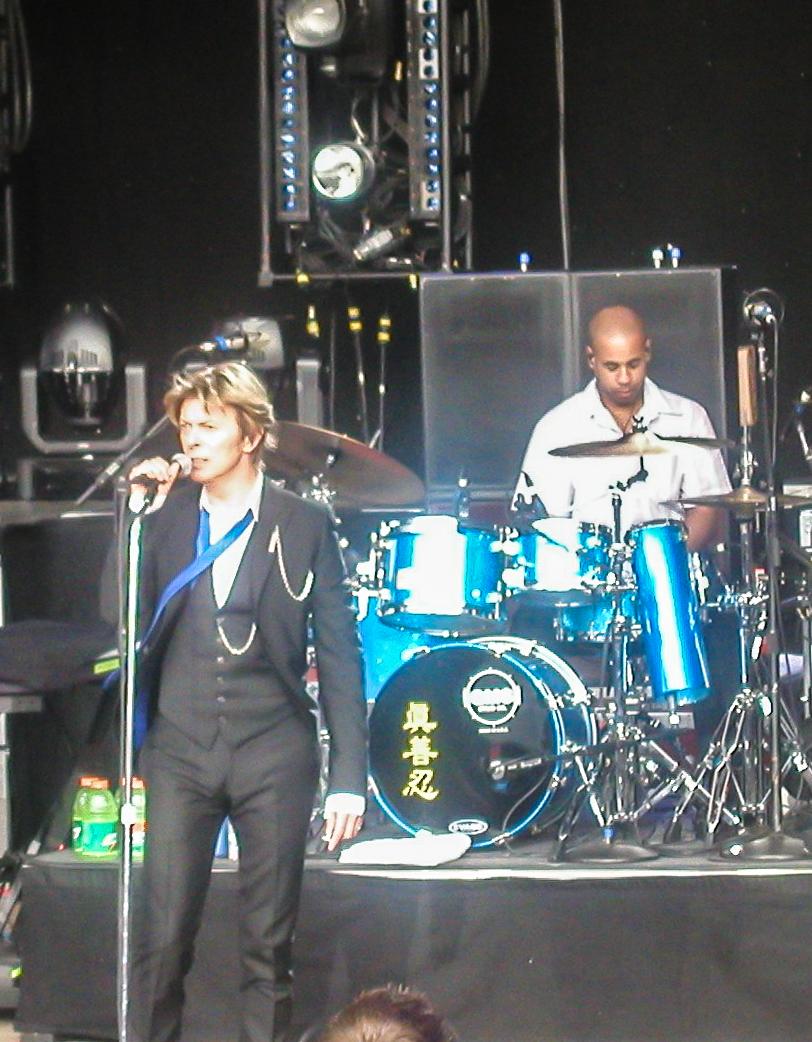 David Bowie with Sterling Campbell on drums in San Francisco in 2002. Campbell's base drum has the Chinese characters for truthfulness, compassion, tolerance, which are the principles of the spiritual practice Falun Gong. (Mark Jeremy/CC BY-SA)