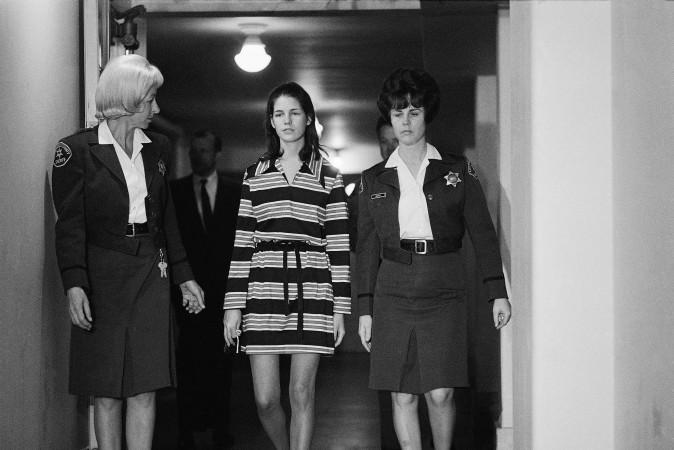 Leslie Van Houten, 19, a member of Charles Manson's "family" who is charged with the murders of Leno and Rosemary LaBianca, is escorted by two deputy sheriffs as she leaves the courtroom in Los Angeles, Dec. 19, 1969. (AP Photo/George Brich)