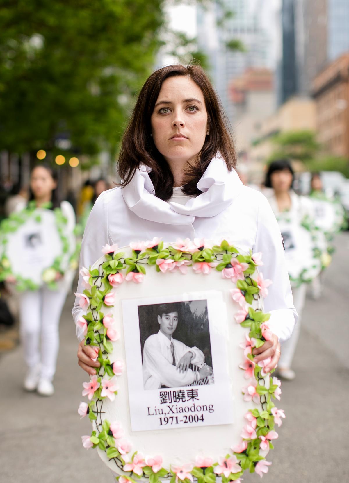 Falun Gong practitioners hold portraits of those killed in the persecution in China during the World Falun Dafa Day parade along 42nd Street in New York, on May 13, 2016. (Samira Bouaou/Epoch Times)