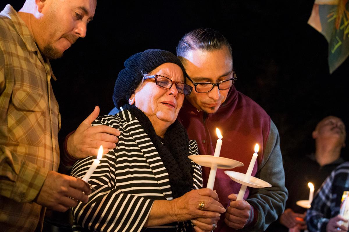Rubia Serna is consoled by her sons Jesse Serna (R) and Frank Serna at the candlelight vigil for Francisco Serna, 73, her husband and their father, in Bakersfield, Calif., on Dec. 13, 2016. (Felix Adamo/The Bakersfield Californian via AP)
