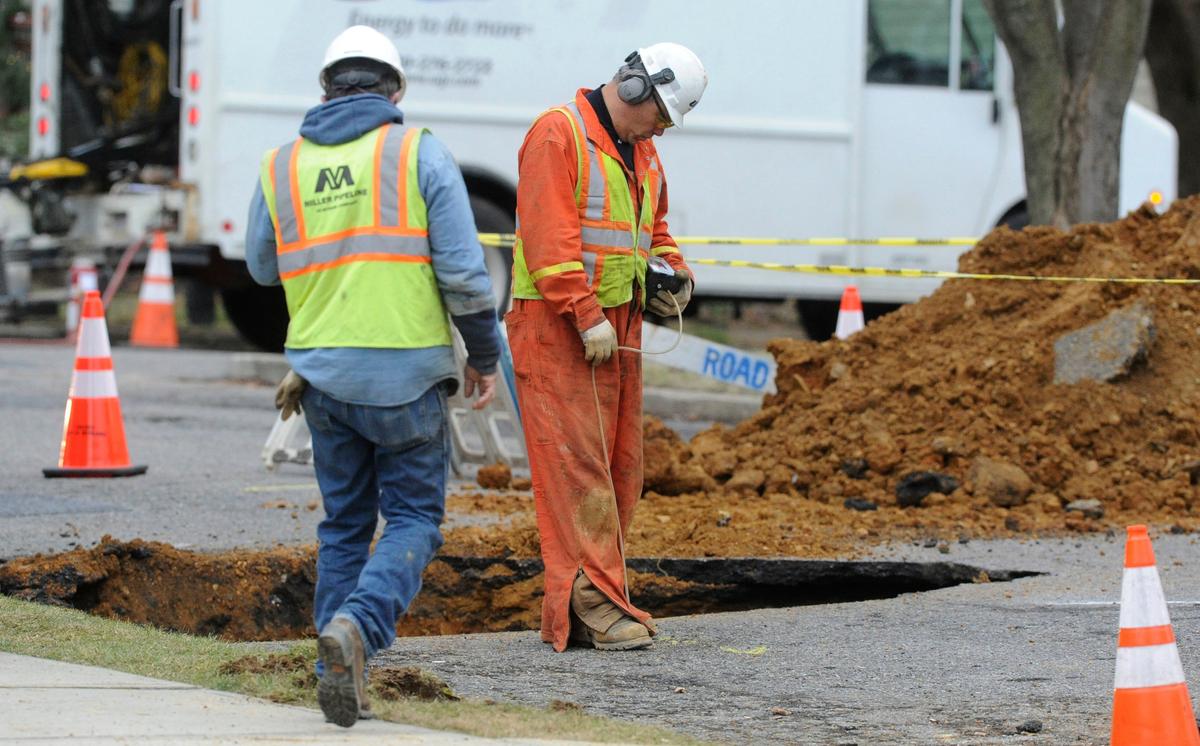 Workers inspect a sinkhole that collapsed part of a street in Bethlehem, Pa., on Dec. 28, 2016. (Sue Beyer/The Express-Times via AP)