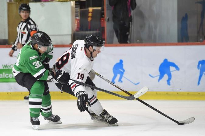 Simon Ferguson of Kowloon Warriors holds off Mathew Lee of Macau Aces in their CIHL league match at Mega Ice on Jan 5, 20017. (Bill Cox/Epoch Times)