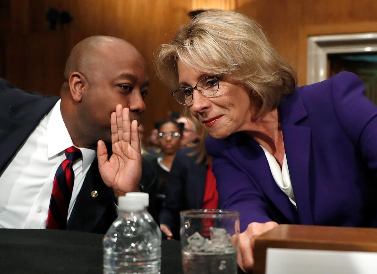 Education Secretary-designate Betsy DeVos talks to Sen. Tim Scott, R-S.C., before testifying on Capitol Hill in Washington on Jan. 17, 2017. (AP Photo/Carolyn Kaster)