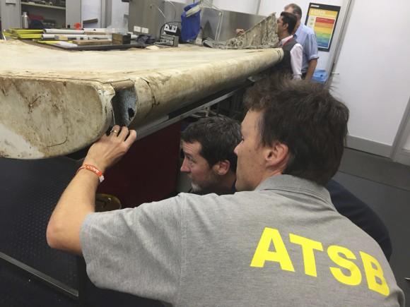 In this July. 20, 2016, file photo released by the Australian Transport Safety Bureau (ATSB), staff examine a piece of aircraft debris at their laboratory in Canberra, Australia. (ATSB via AP)