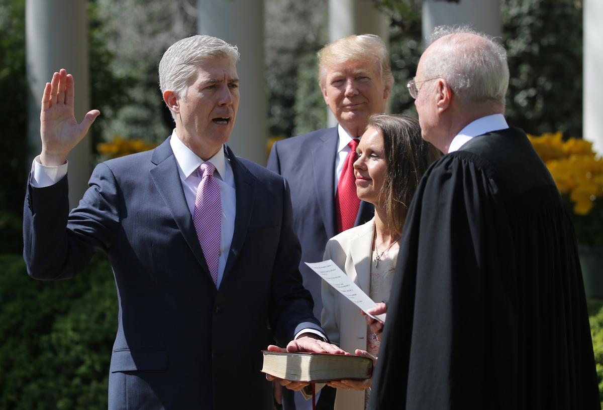 Judge Neil Gorsuch (L) is sworn in as an associate justice of the Supreme Court by Supreme Court Associate Justice Anthony Kennedy (R) , as U.S. President Donald J. Trump (C) watches with Louise Gorsuch in the Rose Garden of the White House in Washington on April 10, 2017. (REUTERS/Carlos Barria)