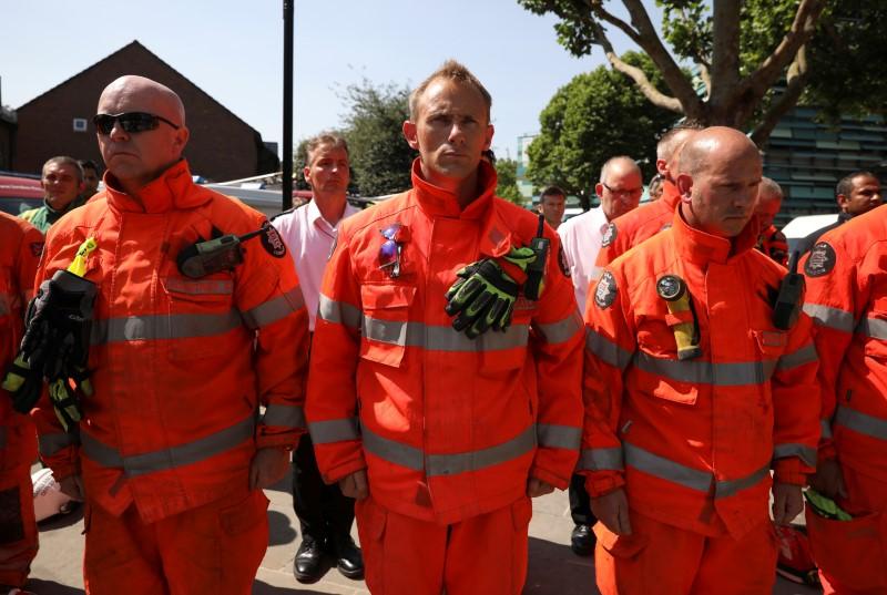Members of the emergency services attend a minute's silence for the victims of the Grenfell Tower fire near the site of the blaze in North Kensington, London, Britain on June 19, 2017. (REUTERS/Marko Djurica)