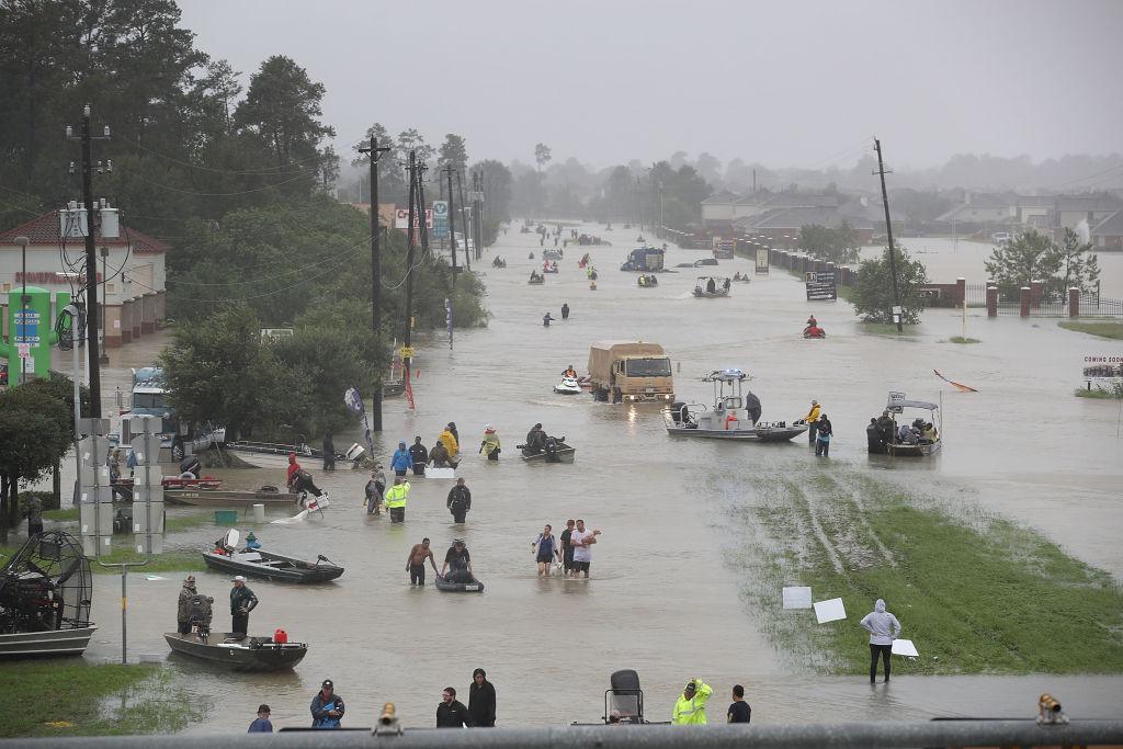 People walk down a flooded street as they evacuate their homes after the area was inundated with flooding from Hurricane Harvey in Houston, Tex., on Aug. 28, 2017. (Joe Raedle/Getty Images)