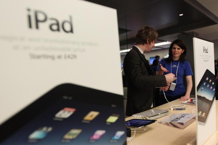 Apple employees help customers with the new iPad on the shop floor at Regent Street's Apple store on May 28, 2010 in London, England.  (Dan Kitwood/Getty Images)