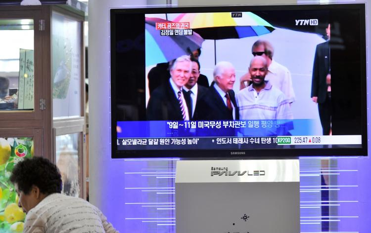 AIJALON GOMES SAVED: A woman walks past a TV screen in Seoul reporting on former U.S. President Jimmy Carter and Aijalon Mahli Gomes, an African-American who was jailed in North Korea.  (Jung Yeon-je/AFP/Getty Images)