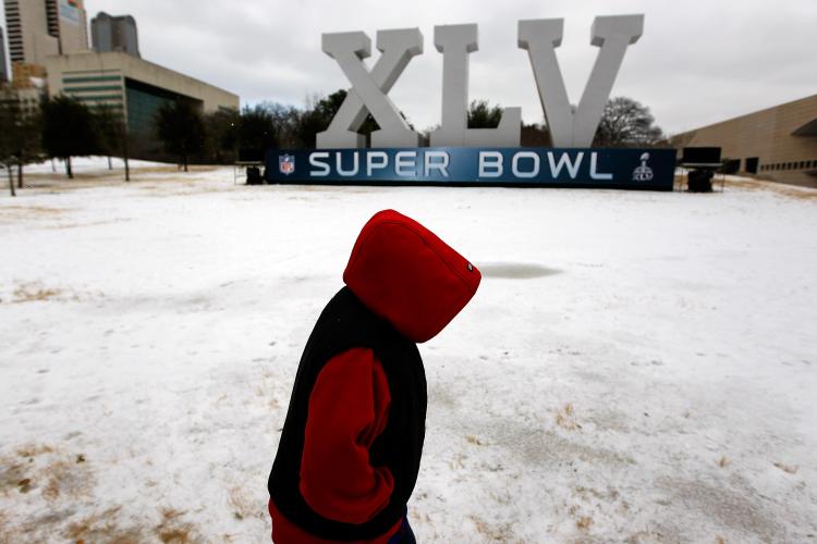 Rolling Blackouts: Robert Garza, 10, walks through snow and ice while visiting an NFL Super Bowl XLV display Feb. 1 in Dallas, Texas. The Electric Reliability Council of Texas imposed rolling blackouts on Feb. 2 to prevent its generators from shutting down. (Tom Pennington/Getty Images)