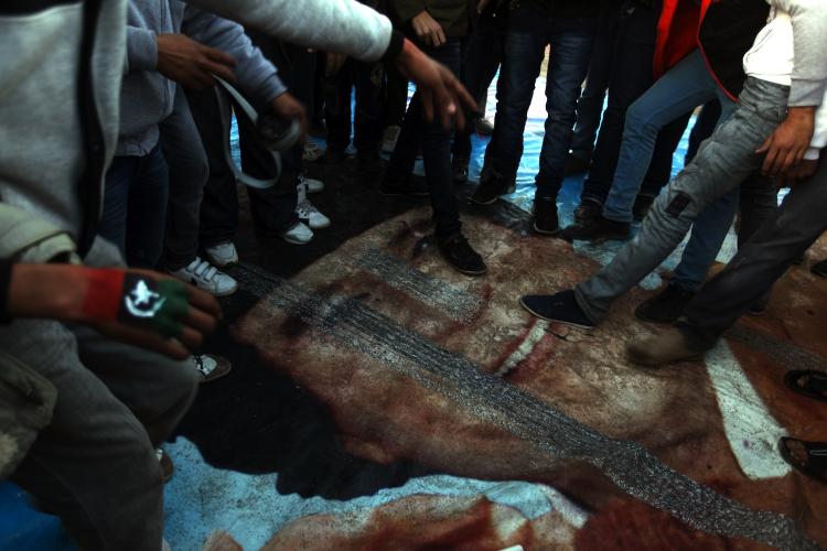 Libyan protesters step on a poster of leader Moamer Gadhafi in the eastern Libyan city of Benghazi on February 28, as world powers ramped up the pressure on Gadhafi's regime and the U.S. urged the international community to work together on further steps to end bloodshed in Libya. (Patrick Baz/Getty Images)
