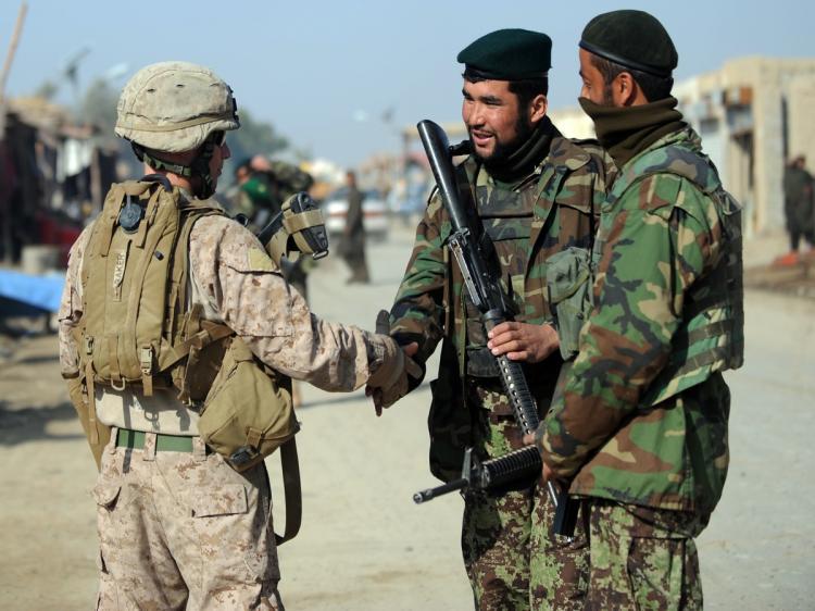 A U.S. Marine of the 2nd Battalion, 1st Marines Regiment (L) shakes hands with Afghanistan national army (ANA) soldiers during a patrol in Garmser, Helmand Province, on March 7. There are around 140,000 international troops, two-thirds of them from the United States in Afghanistan fighting the militant Islamist Taliban. (Adek Berry/AFP/Getty Images)