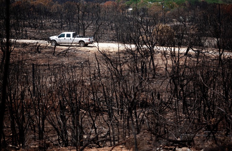 A utility company truck drives through a burned out area in the Gaines Bend neighborhood on April 26 near Strawn, Texas. On May 30, two wildfires near Amarillo have destroyed at least 12 homes. (Tom Pennington/Getty Images)