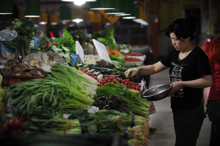 People shop for vegetables in a market in Beijing on May 11, 2011. The communist officials have their own safe food supply. (Peter Parks/AFP/Getty Images)