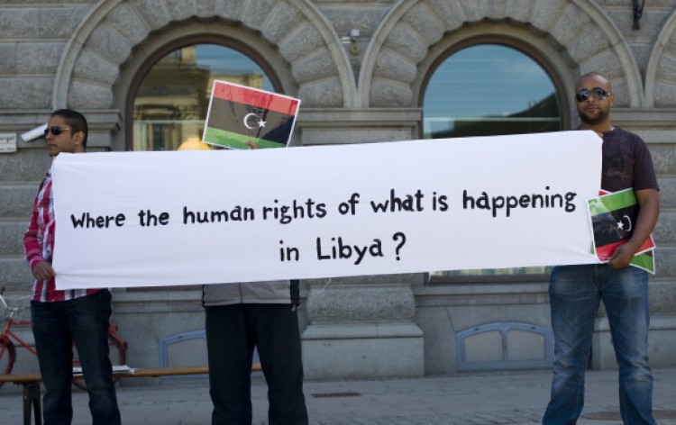 People hold the flag of the old Libya during a demonstration in support of the Libyan rebels and in protest near the Swedish Parliament in Stockholm on May 20.  (Jonathan Nackstrand/AFP/Getty Images)