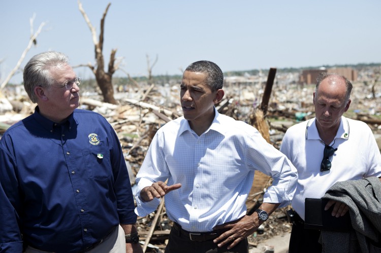 President Barack Obama (C) rolls up his sleeve and speaks to press while touring tornado damge in Joplin, Mo. on May 29. He is accompanied by Missouri Gov. Jay Nixon (L) and Joplin Mayor Michael Woolston (R). (Brendan Smialowski/AFP/Getty Images)