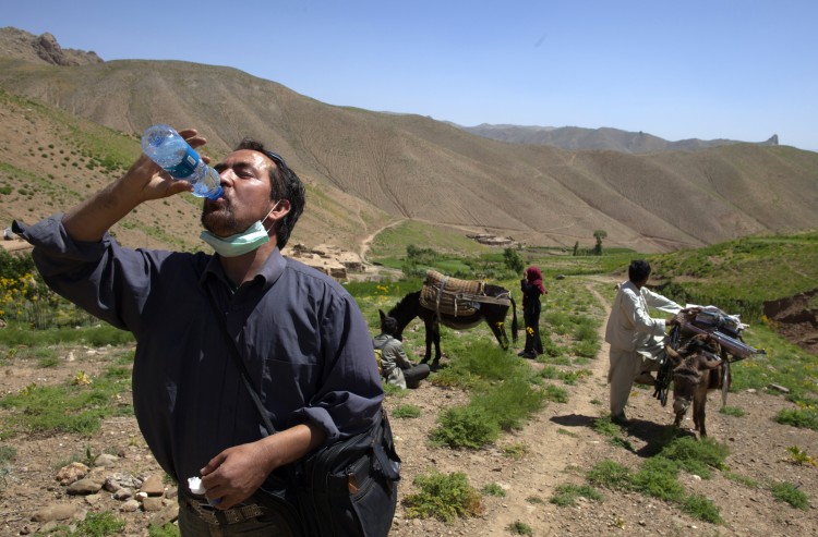 Dr. Jaghori (R) takes a water break after reaching to the top of the mountain pass on a two hour trek June 9, 2011. (Paula Bronstein/Getty Images)