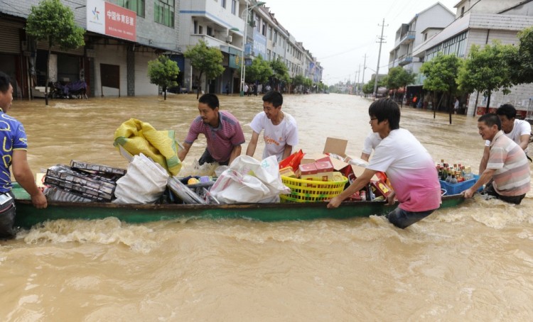 Chinese residents transport their belongings by boat through flood waters after heavy rains hit Lanxi, east China's Zhejiang province on June 20, 2011. (STR/AFP/Getty Images)