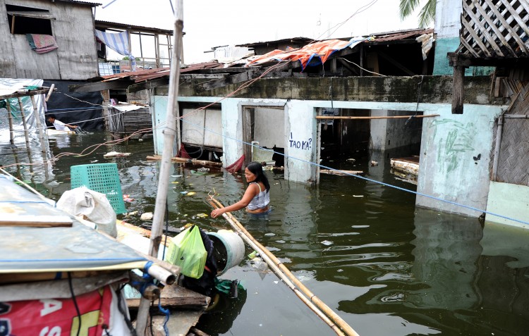 A woman maneuvers through flood waters caused by a passing typhoon. (Noel Celis/AFP/Getty Images)