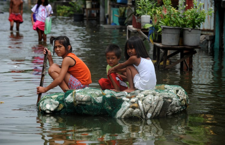 Children row a makeshift raft through flood waters caused by a passing typhoon in Malabon. (Noel Celis/AFP/Getty Images)