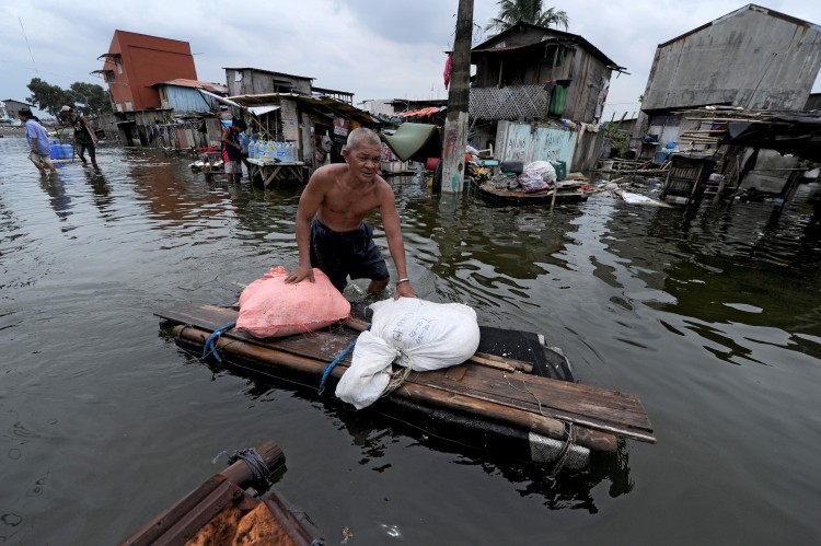 A man pushes his belongings through flood water caused by a passing typhoon in Malabon, Metro Manila on June 21, 2011. (Noel Celis/AFP/Getty Images)