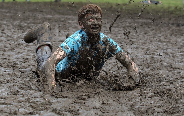 Tom Wilder, 17 from Kent, dives in the mud at the Glastonbury Festival site at Worthy Farm, Pilton on June 23, 2011 in Glastonbury, England. (Matt Cardy/Getty Images)