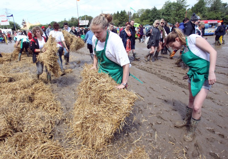 Market traders lay straw down in market areas close to the Pyramid Stage in an attempt to dry them at the Glastonbury Festival site at Worthy Farm, Pilton on June 23, 2011. (Matt Cardy/Getty Images)