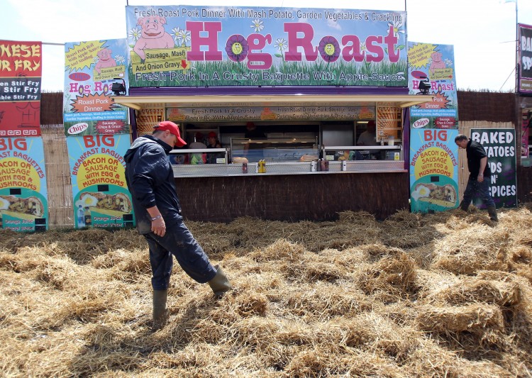 Market traders lay straw down in market areas close to the Pyramid Stage. (Matt Cardy/Getty Images)