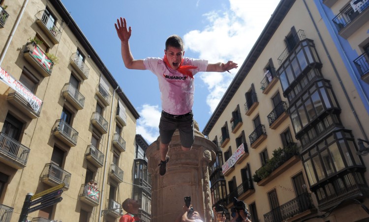 A reveller jumps from a fountain to be caught by the crowd during the Chupinazo, marking the first day of the San Fermin running-of-the-bulls on July 6, 2011. (Dennis Doyle/Getty Images)