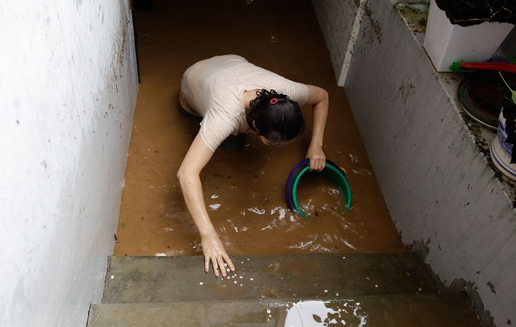 A woman cleans up in the aftermath of a torrential rain storm hit the capital city on July 27, 2011 in Seoul, South Korea. (Chung Sung-Jun/Getty Images)