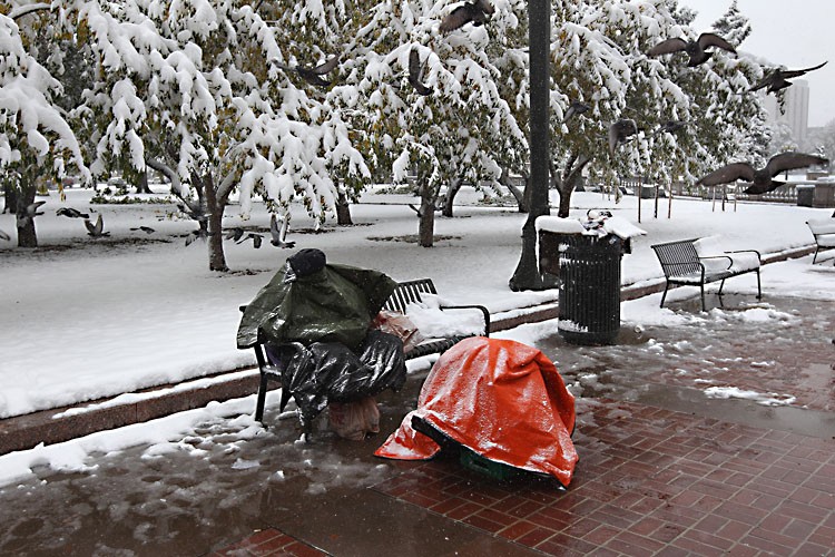 A man sits covered against the cold and snow in Denver, Colo., on Oct. 26. (John Moore/Getty Images)