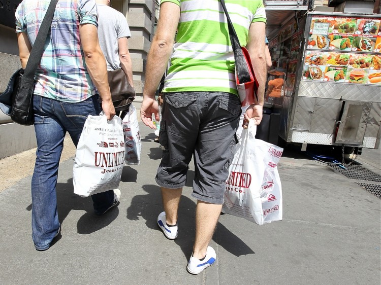 Pedestrians carry shopping bags