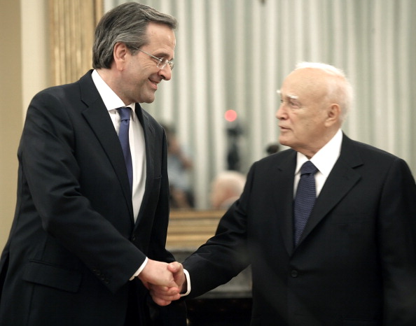 Newly appointed Greek Prime Minister Antonis Samaras (L) shakes hands with President Karolos Papoulias after Samara was sworn in at the presidential palace as President Karolos Papoulias (C rear) June 20, 2012 in Athens, Greece. Samaras pledged to pull his debt-stricken country back from the brink of bankruptcyin his first comments after being sworn in. (Photo by Milos Bicanski/Getty Images)