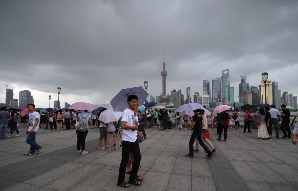 People walk along the Bund as storm clouds gather over the Huangpu River in Shanghai on August 2, 2012.  (Peter Parks/AFP/GettyImages)