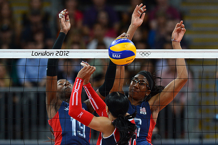 Dominican Republic's Milagros Cabral De La Cruz (C) spikes as Destinee Hooker (L) and Foluke Akinradewo of the U.S. attempt to block during the Women's quarterfinal volleyball match between the U.S. and Dominican Republic in the 2012 London Olympic Games. (Kirill Kudryavtsev/AFP/GettyImages)