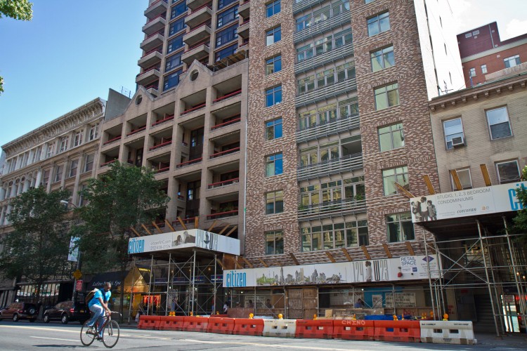 A cyclist rides past Citizen, a new condominium building in Manhattan on 124 W. 23rd St. (Benjamin Chasteen/The Epoch Times) 