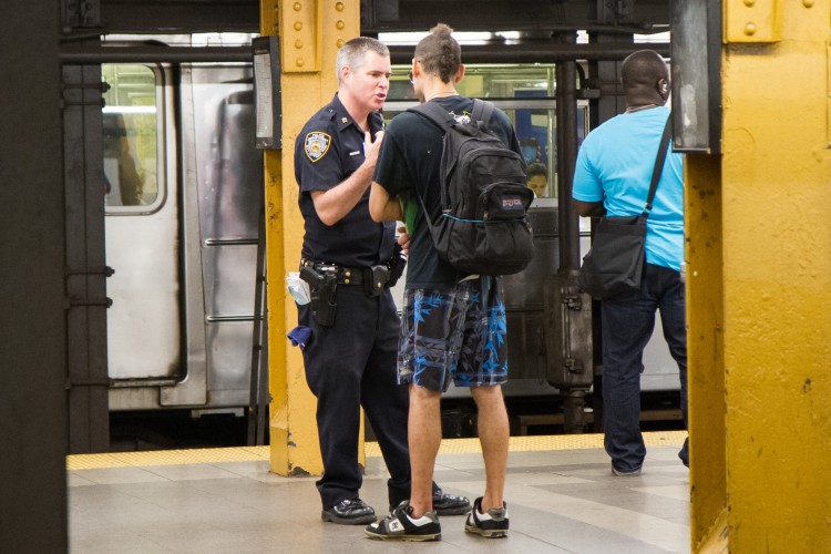 A young man is questioned before being frisked by a police officer at the Penn Station subway platform in Manhattan on Aug. 7