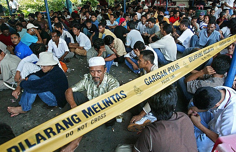 Illegal immigrants arrested in Kuala Lumpur after not having travel documents. Australia transfer arrangement with Malaysia may help improve conditions for asylum seekers in Malaysia but whether it goes ahead and can stop the boats remains to be seen. (Jimin Lai/AFP/Getty Images)