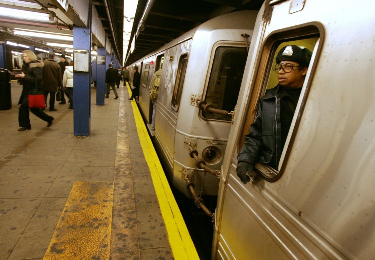 A subway conductor waits for passengers to board the train