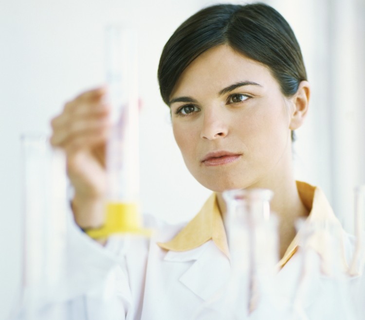 Female scientist examining liquid in a test tube. (Photos.com)