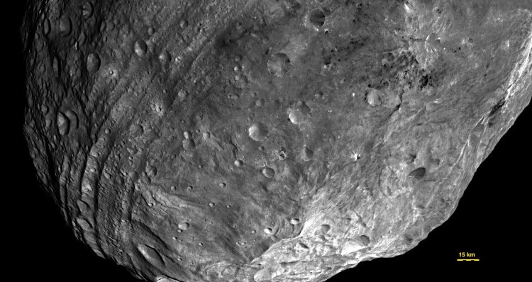 VESTA: In this image, obtained by Dawn's framing camera, a peak at Vesta's south pole is seen at the lower right. The grooves in the equatorial region are about six miles (10 kilometers) wide. (NASA/JPL-Caltech/UCLA/MPS/DLR/IDA)