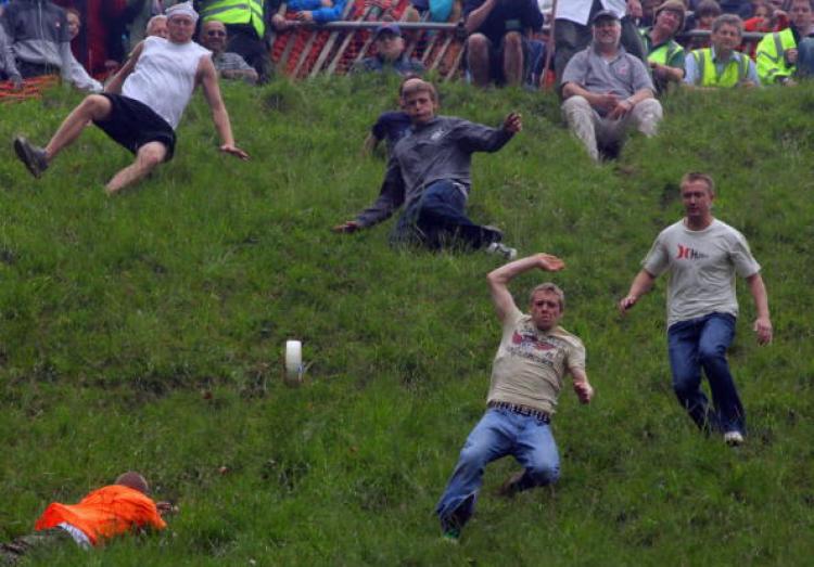 Contestants in the men's race chase a Double Gloucester Cheese down the steep gradient of Cooper's Hill during the annual Bank Holiday tradition of cheese-rolling on May 25, 2009 in Brockworth, Gloucestershire, England.  (Matt Cardy/Getty Images)