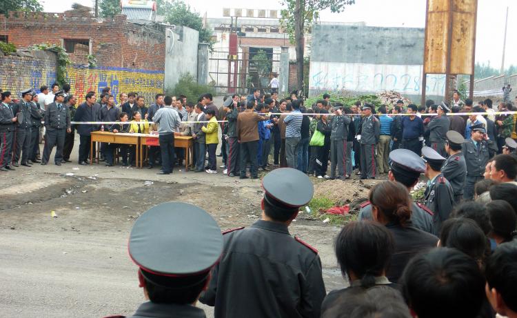 Chinese security guards surround the entrance to a mine as family members arrive to find out the fate of the miners, following a gas explosion in Pingdingshan, central China's Henan province on September 8, 2009. (AFP/Getty Images)